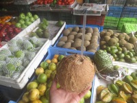 Enjoying a fresh coconut at the fruit and vegetable stand.